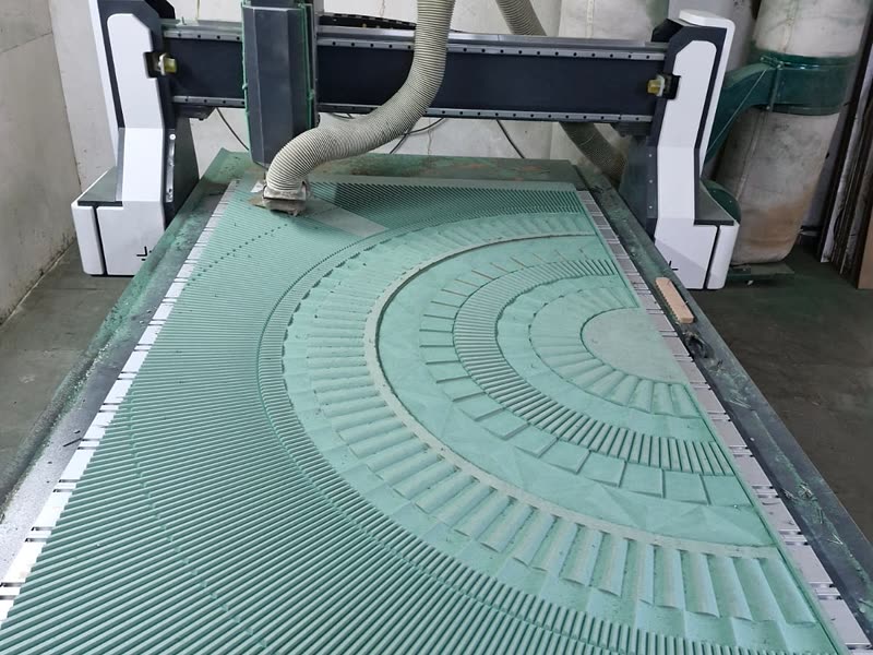 CNC router mid-cut on a nested radial pattern, dust extraction running, Bijwasan workshop
