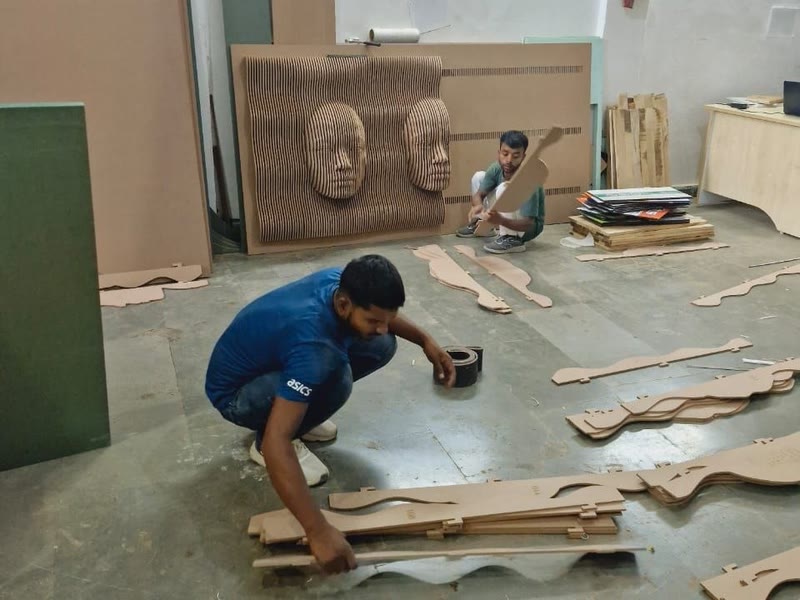 Numbered CNC cut ribs laid out in sequence across the floor before assembly of a parametric wall panel, Dream3 Bijwasan workshop