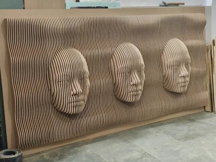 Finished parametric wall panel with three faces rising out of a field of stacked CNC cut ribs, seen square on at Dream3 Bijwasan