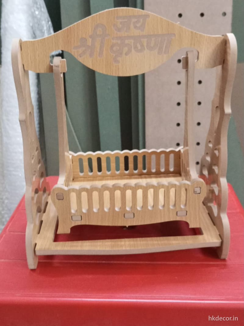 Laser cut jhula swing with cut lettering across the top rail, natural board