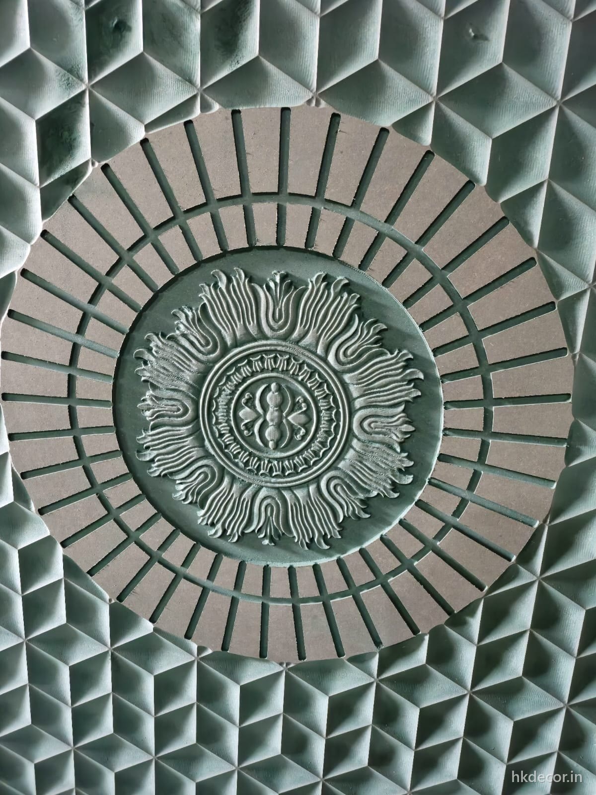 Close up of a CNC cut wall panel showing the faceted ground and carved radial centre