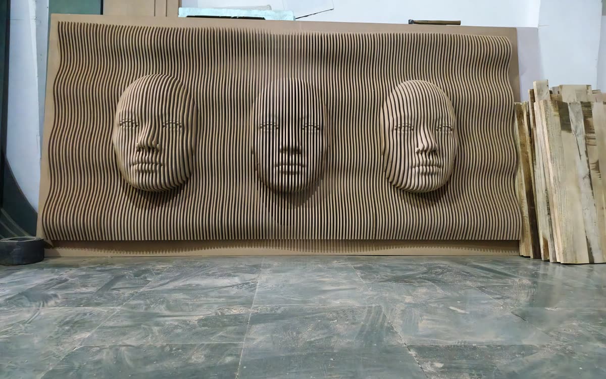 CNC cut parametric wall panel with three carved faces rising from a stacked-rib field, Dream3 Bijwasan