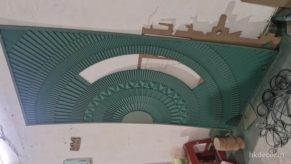 CNC cut radial pattern panels fixed across a curved ceiling soffit, primed
