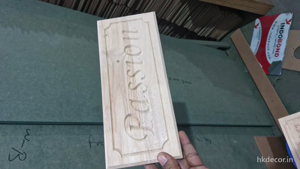 CNC cut signage board with lettering raised out of the surface, in raw board before finishing