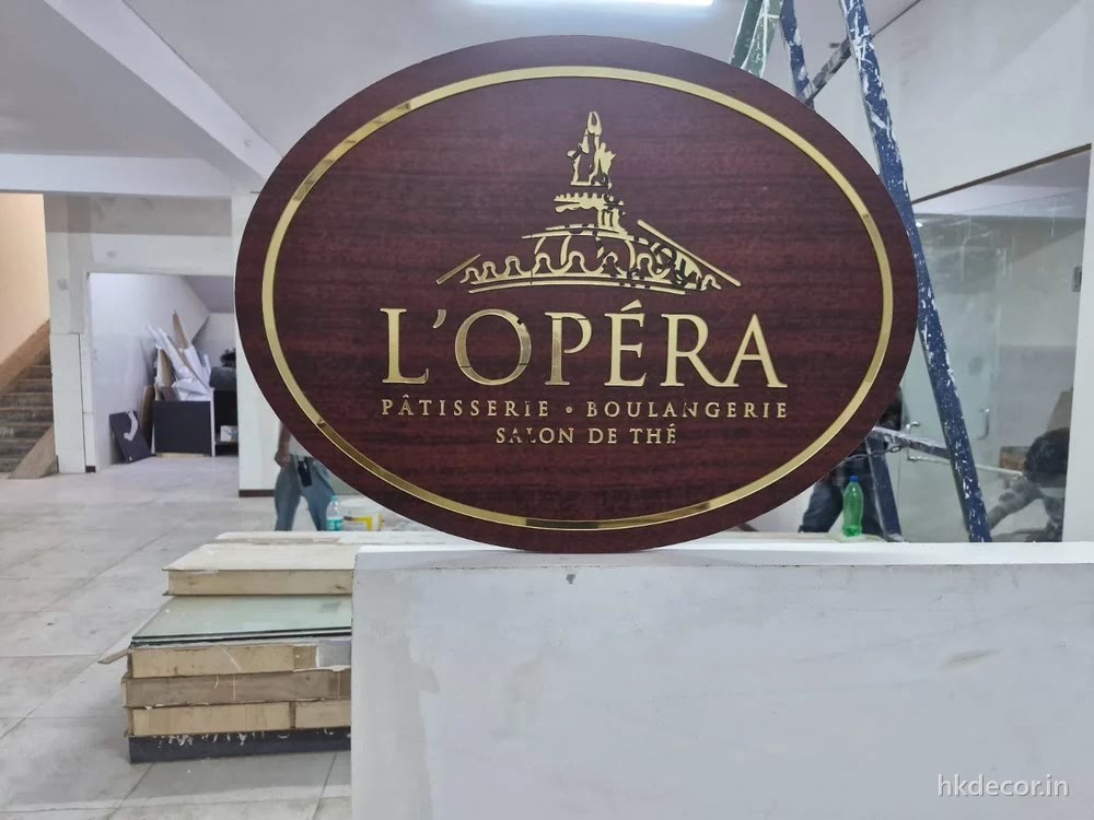 CNC cut oval signage board with raised gilded lettering, mounted on an interior wall